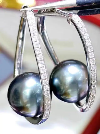 Midnight Orbit Earrings: 925 sterling silver hoop earrings with a central freshwater pearl encircled by lab-created sapphire stones.