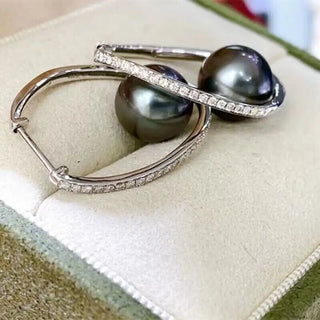 Midnight Orbit Earrings: 925 sterling silver hoop earrings with a central freshwater pearl encircled by lab-created sapphire stones.