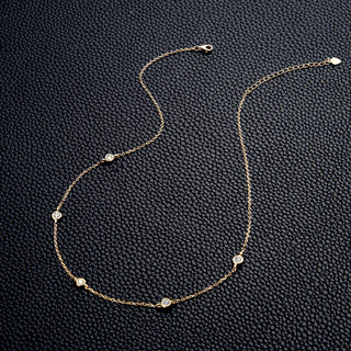 Round Cut Bezel Moissanite Necklace in 18K gold with minimalist bezel setting and adjustable chain.