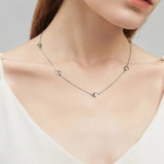 Round Cut Bezel Moissanite Necklace in 18K gold with minimalist bezel setting and adjustable chain.