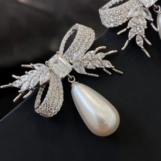 Twilight Bowdrop stud earrings for women: 925 sterling silver bow-shaped studs with freshwater pearls and lab-created sapphire accents, weighing 16 g.