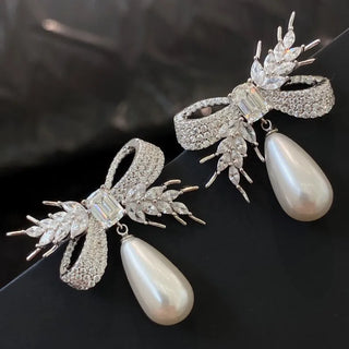 Twilight Bowdrop stud earrings for women: 925 sterling silver bow-shaped studs with freshwater pearls and lab-created sapphire accents, weighing 16 g.